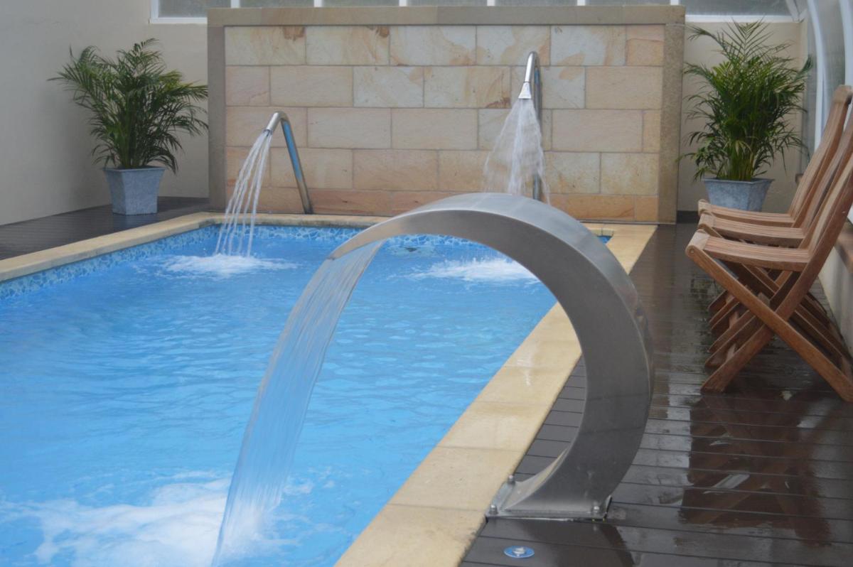 una piscina con una fuente de agua en una casa en Hotel Balneario De Alceda, en Alceda