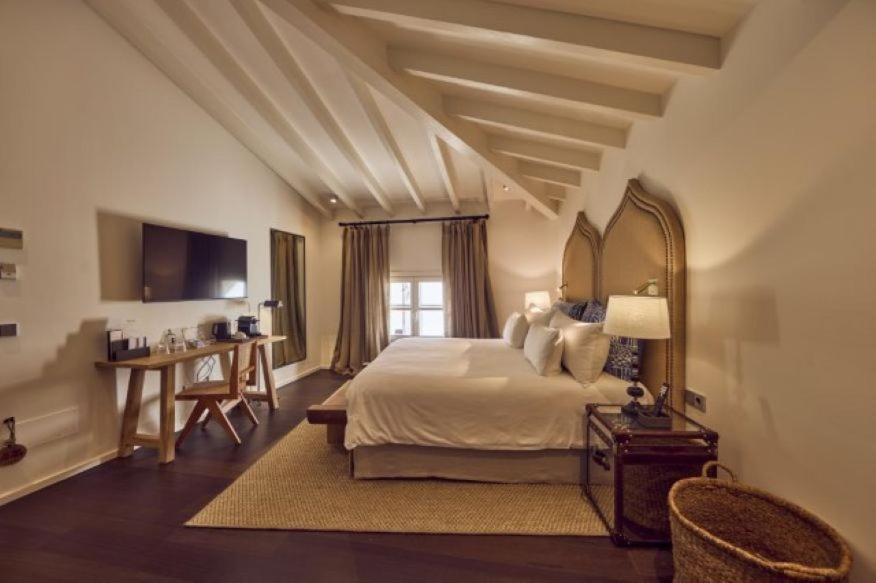 Un dormitorio con una cama y un escritorio con televisión. en Puro Hotel Oasis Urbano, en Palma de Mallorca