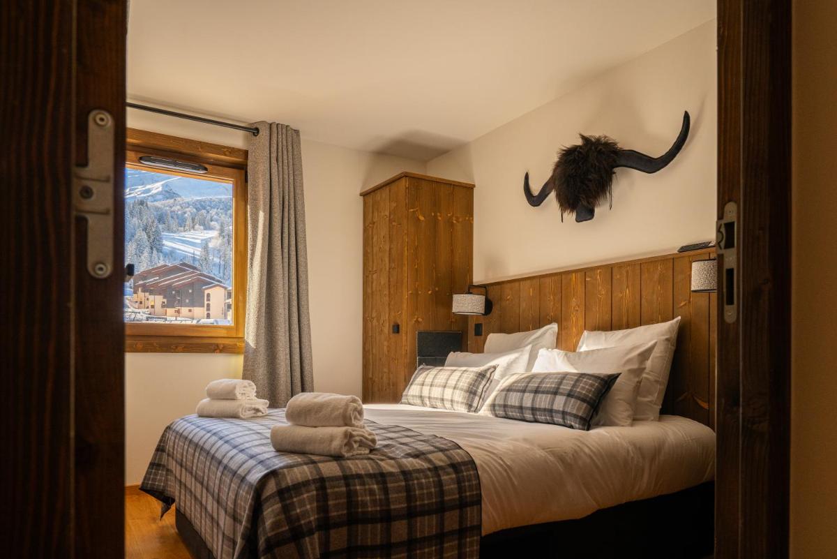 - une chambre avec un lit avec une tête de dinosaure sur le mur dans l'établissement Résidence l'Ecrin d'Argent by My Mountain Resort, à Valmorel