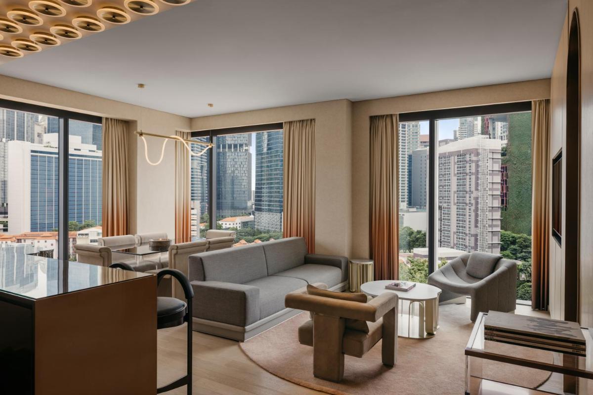 a living room with a couch and chairs and windows at Mondrian Singapore Duxton in Singapore