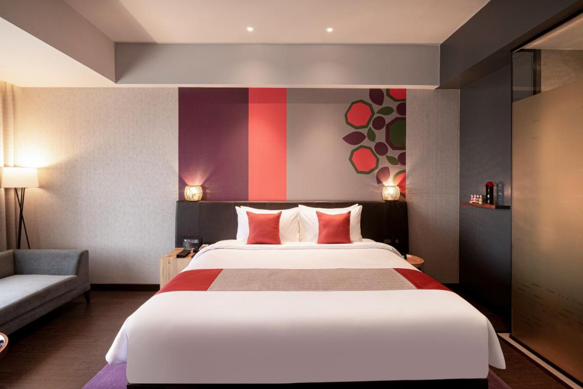 a hotel room with a large bed and a couch at Grand Mercure Bengaluru at Gopalan Mall - An Accor Brand in Bengaluru a hotel room with a large bed and a couch at Grand Mercure Bengaluru at Gopalan Mall - An Accor Brand in Bengaluru