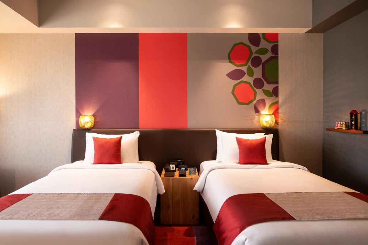 two beds in a hotel room with red accents at Grand Mercure Bengaluru at Gopalan Mall - An Accor Brand in Bengaluru two beds in a hotel room with red accents at Grand Mercure Bengaluru at Gopalan Mall - An Accor Brand in Bengaluru