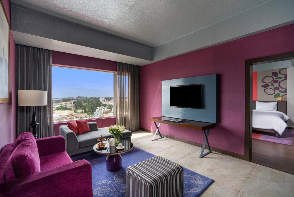 a living room with a purple wall at Grand Mercure Bengaluru at Gopalan Mall - An Accor Brand in Bengaluru a living room with a purple wall at Grand Mercure Bengaluru at Gopalan Mall - An Accor Brand in Bengaluru