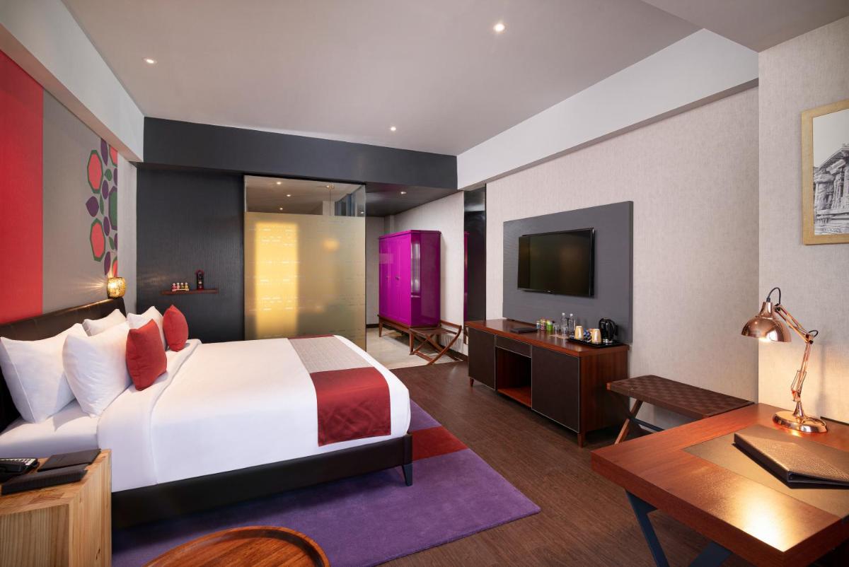 a bedroom with a bed and a desk and a tv at Grand Mercure Bengaluru at Gopalan Mall - An Accor Brand in Bengaluru a bedroom with a bed and a desk and a tv at Grand Mercure Bengaluru at Gopalan Mall - An Accor Brand in Bengaluru