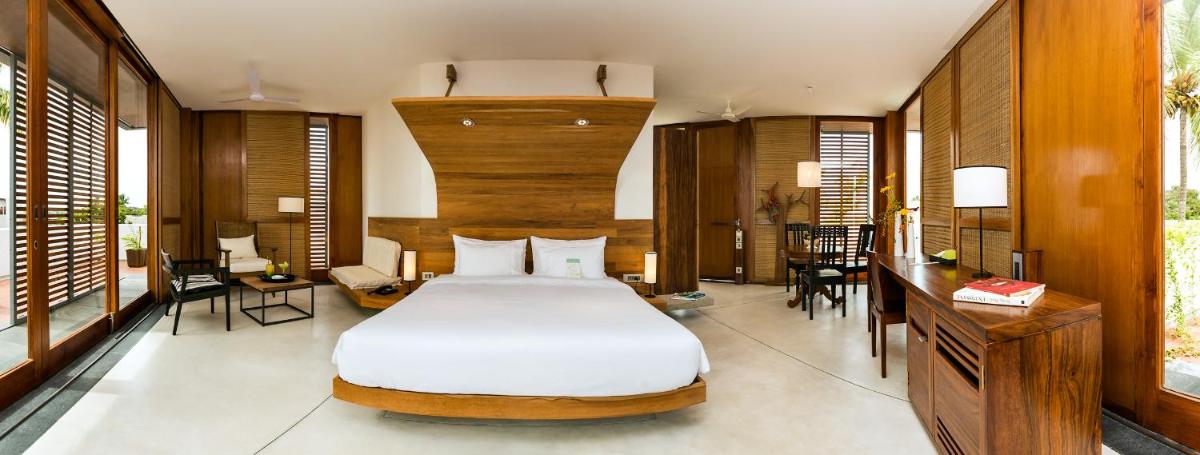 a bedroom with a bed and a table and chairs at La Villa in Puducherry