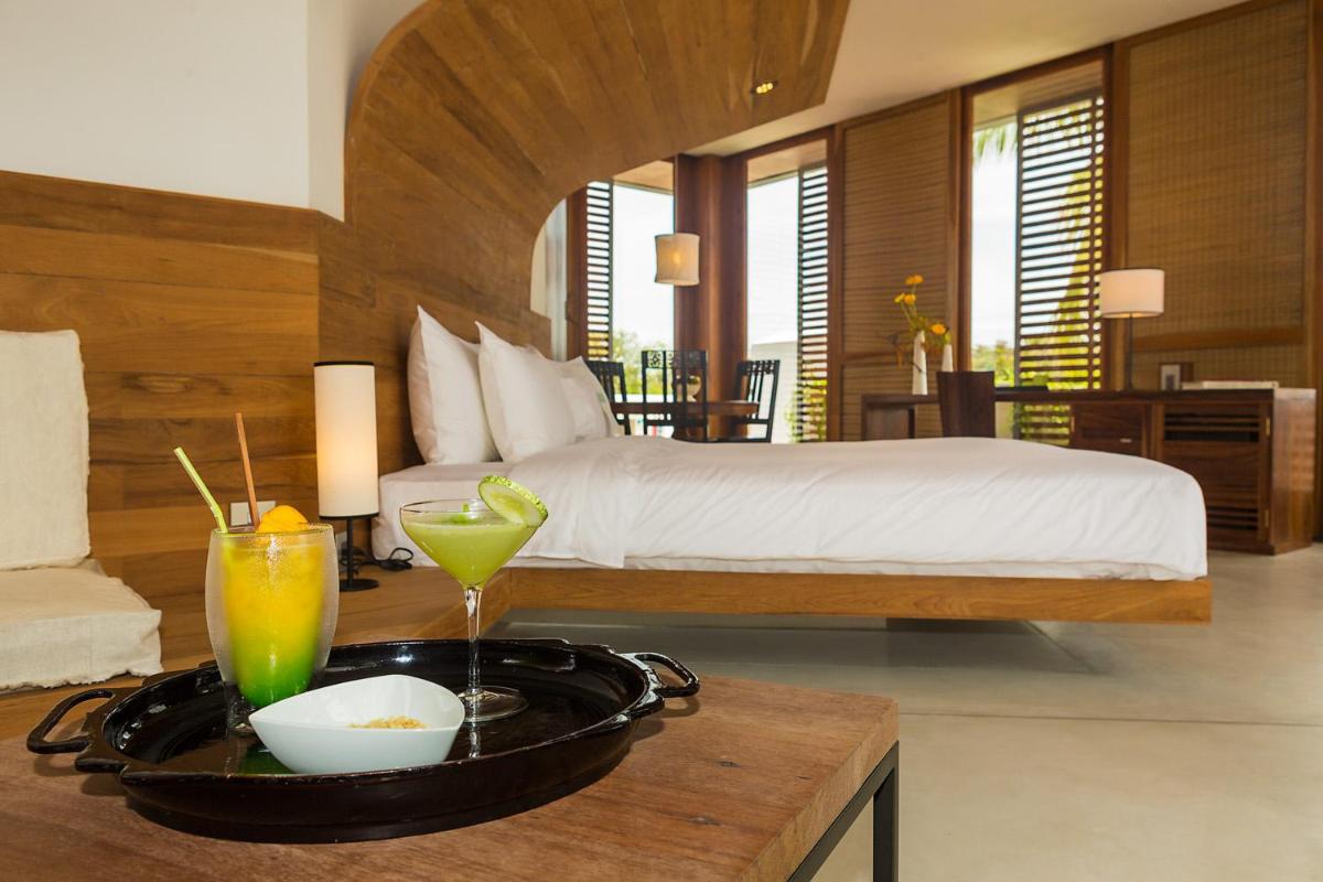 a hotel room with a bed and a tray of food at La Villa in Puducherry