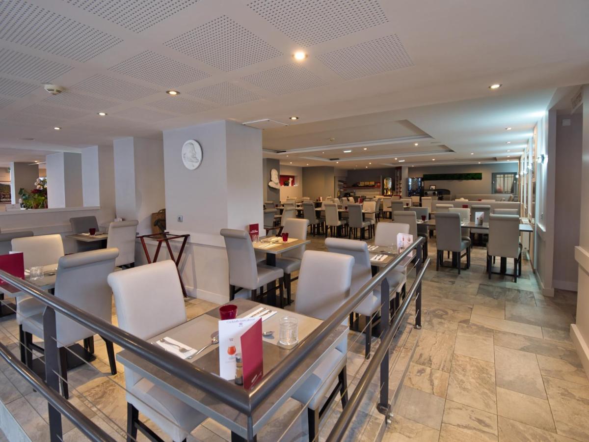 une salle à manger avec des tables et des chaises dans un restaurant dans l'établissement La Table de Gustave, à Ornans