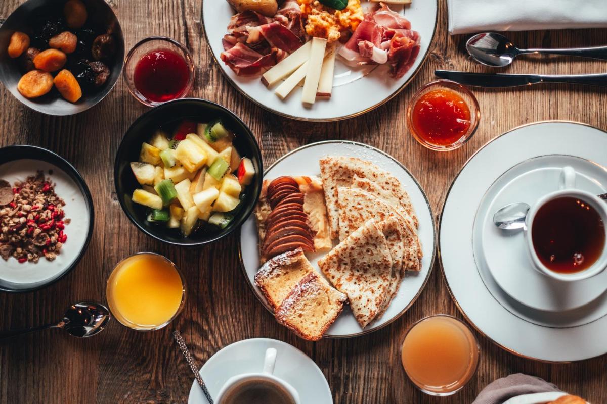 une table en bois avec des assiettes de nourriture dessus dans l'établissement Excelsior Chamonix Hôtel & Spa, à Chamonix-Mont-Blanc
