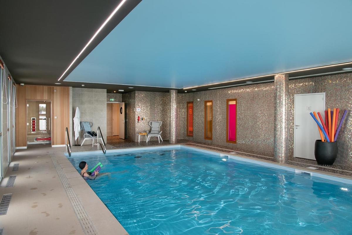 un enfant allongé sur le sol dans une piscine dans l'établissement Le Critérium, à Écouflant