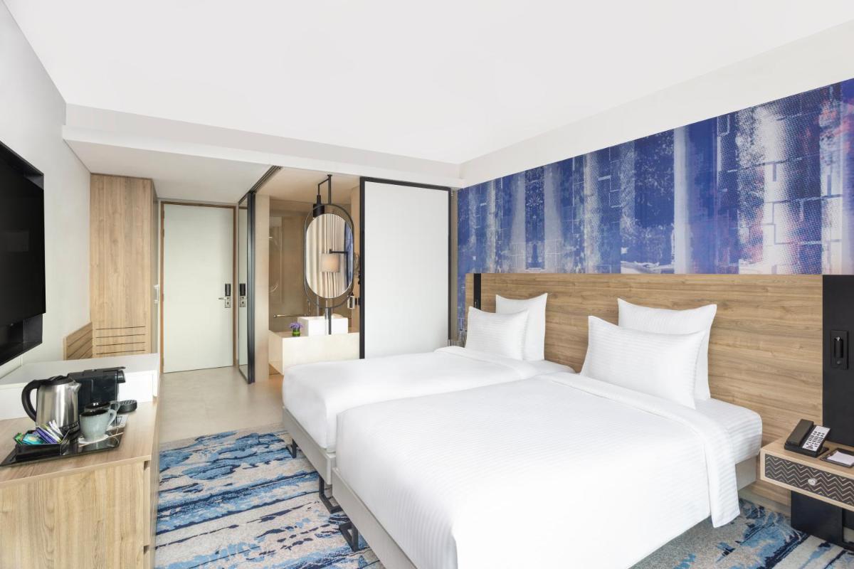 a hotel room with a bed and a television at Novotel New Delhi City Centre in New Delhi a hotel room with a bed and a television at Novotel New Delhi City Centre in New Delhi