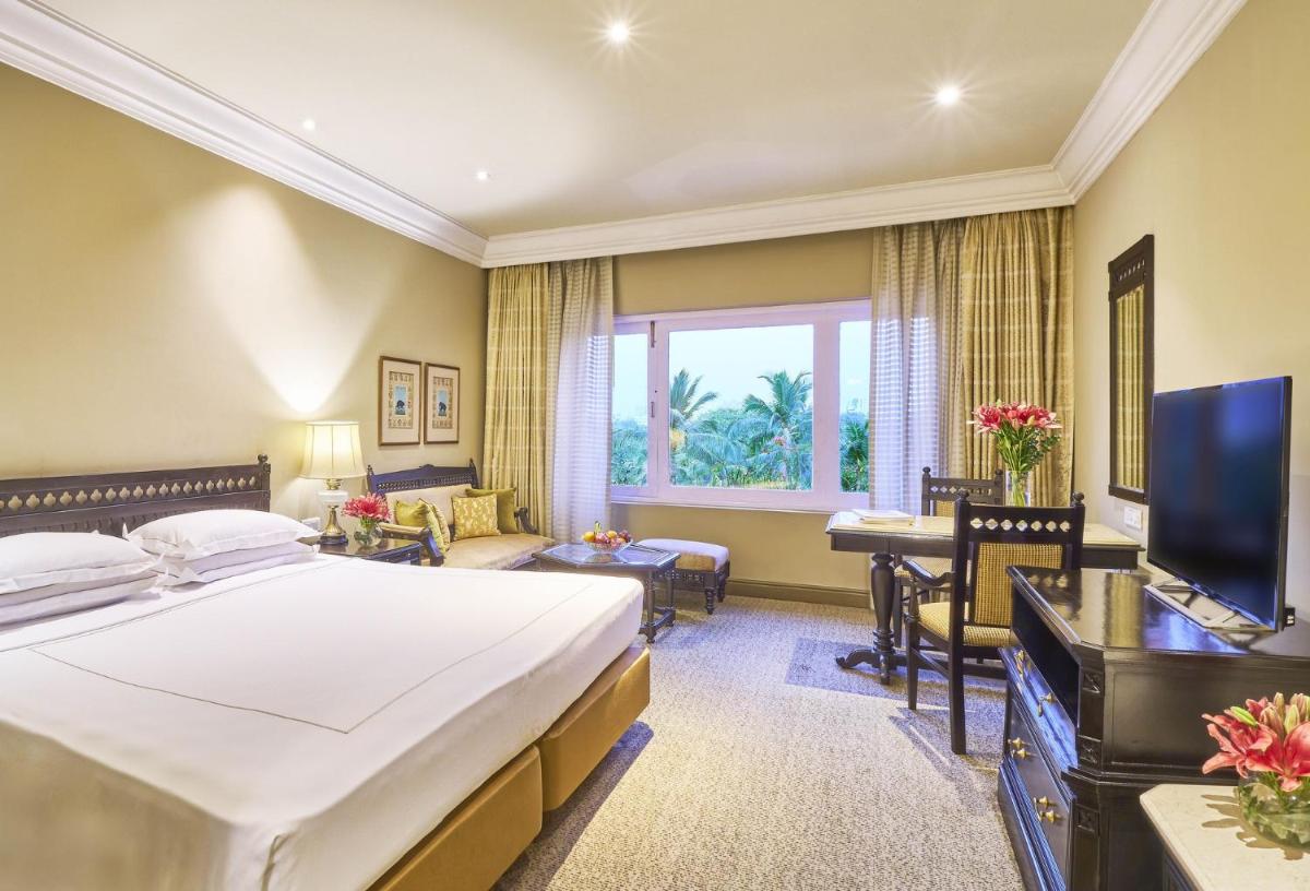 a hotel room with a large bed and a desk at Taj Bengal in Kolkata