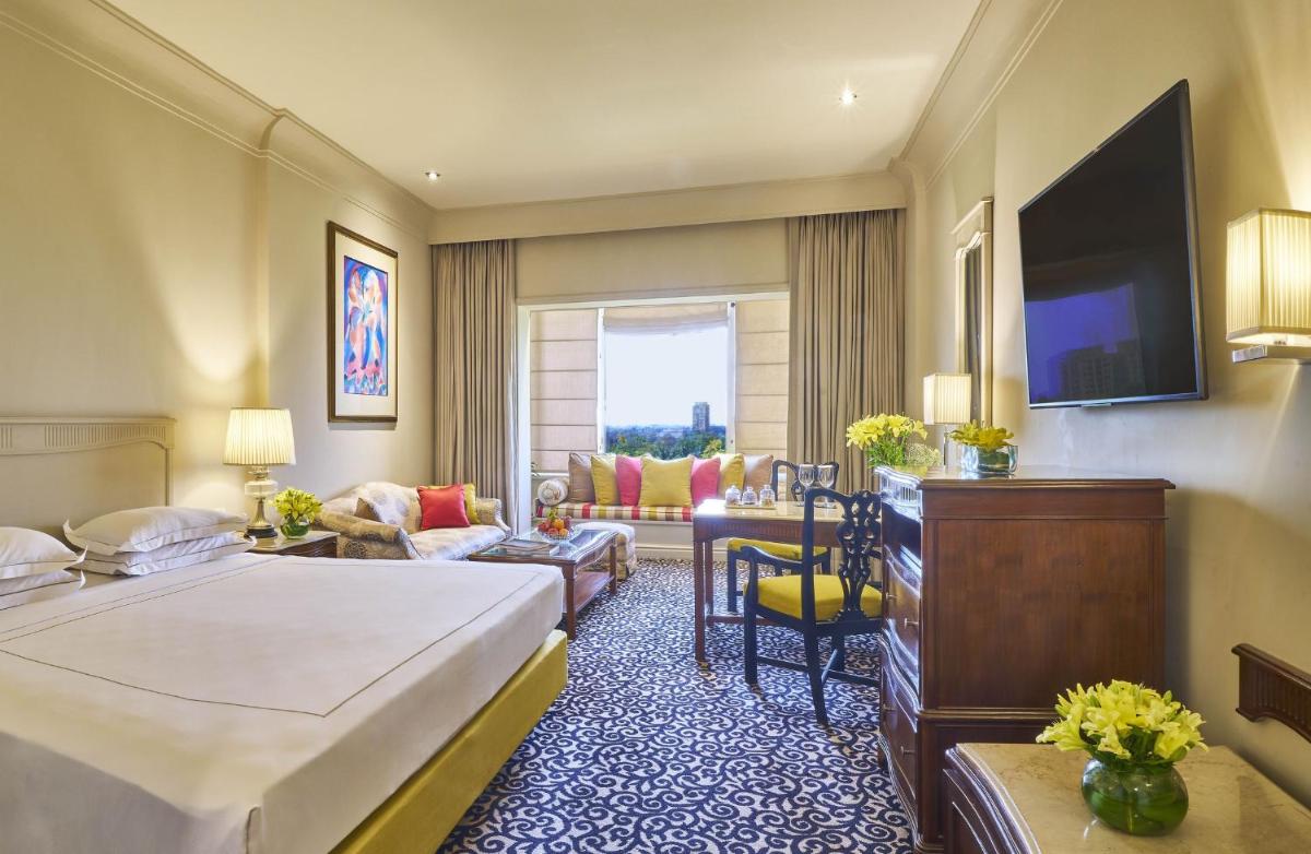 a hotel room with a bed and a living room at Taj Bengal in Kolkata