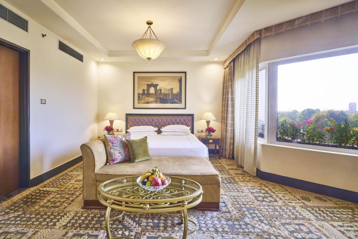 a hotel room with a bed and a large window at Taj Bengal in Kolkata