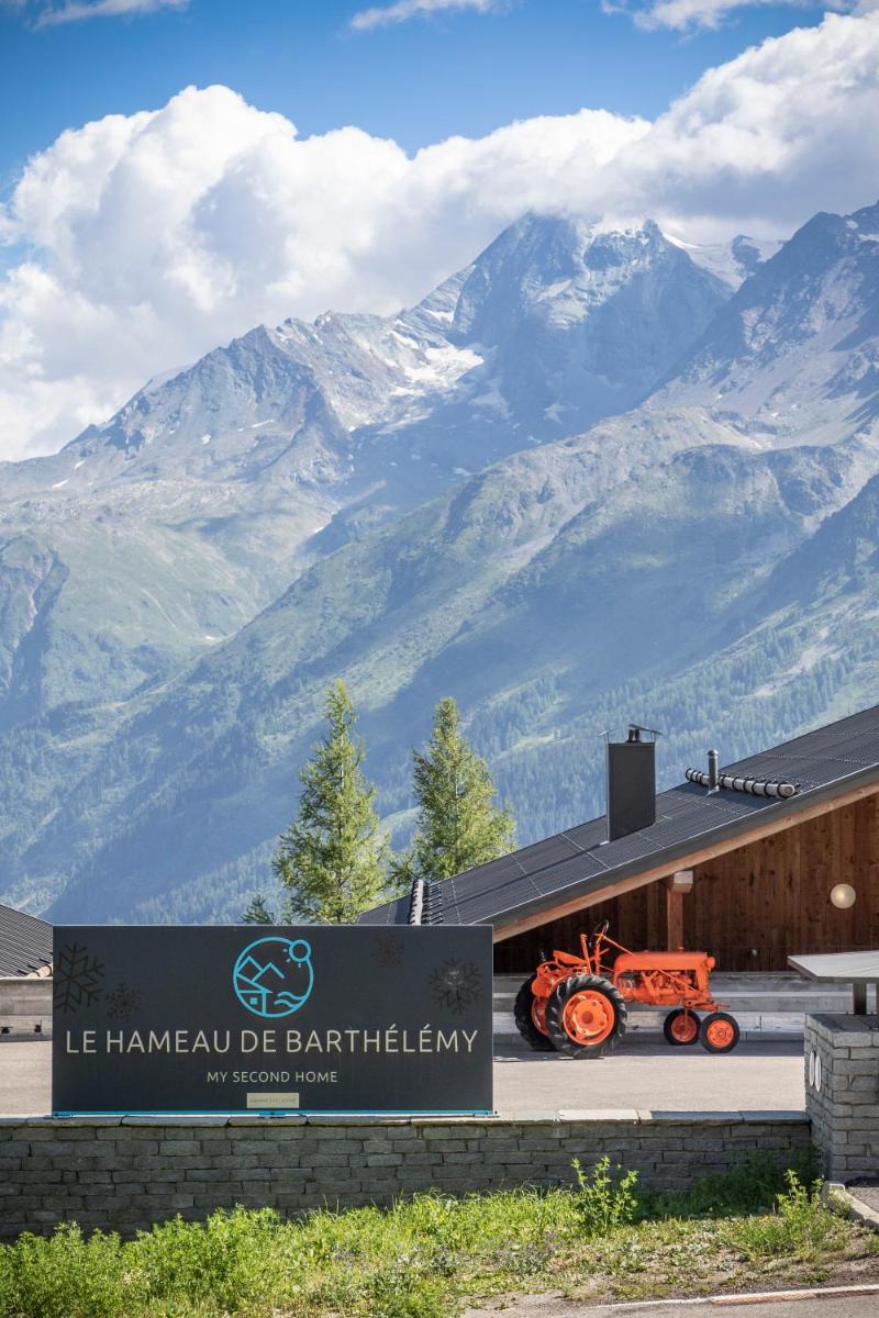 un panneau avec un tracteur sur le côté d'un bâtiment avec des montagnes dans l'établissement TERRESENS - Le Hameau de Barthélémy, à La Rosière