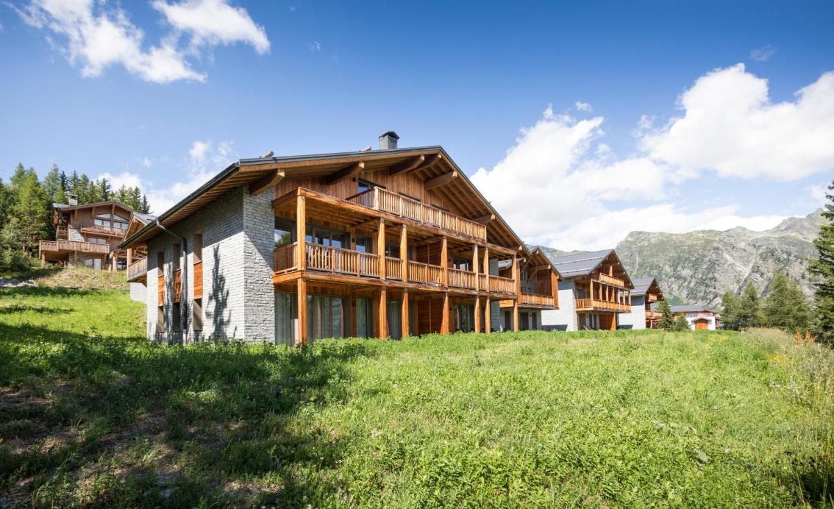 une maison sur une colline avec des montagnes en arrière-plan dans l'établissement TERRESENS - Le Hameau de Barthélémy, à La Rosière