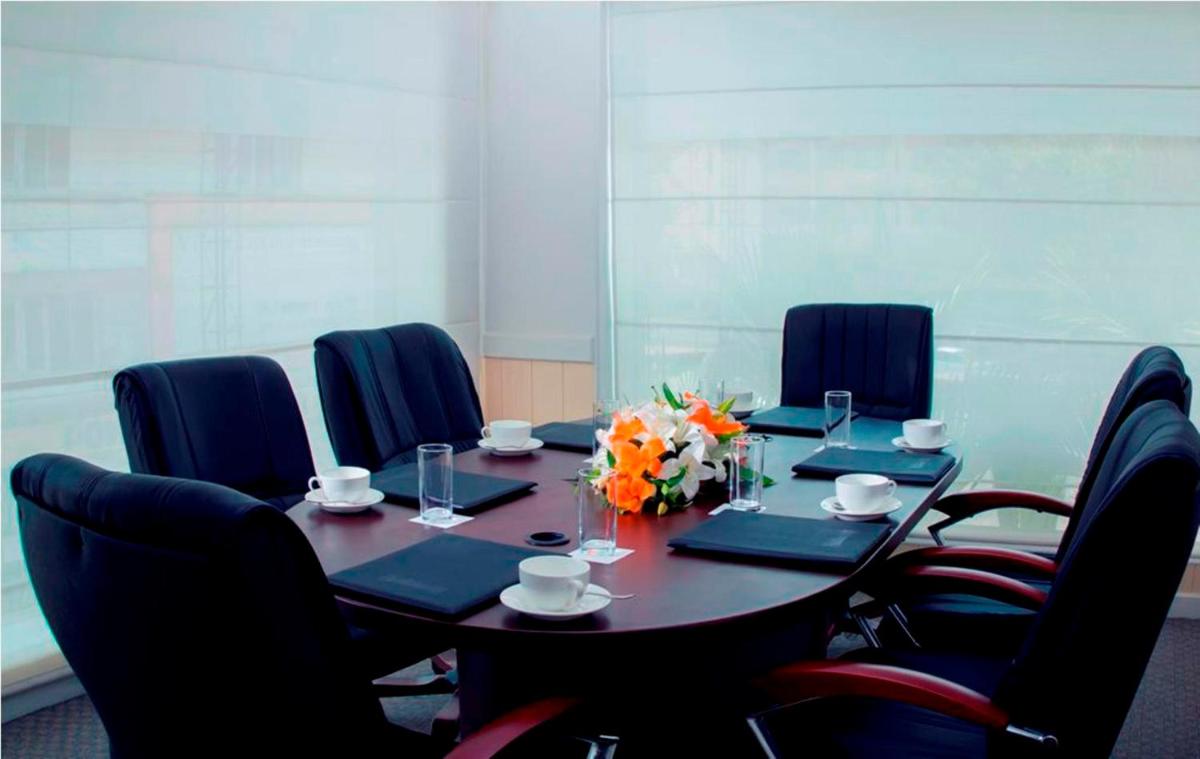 a conference room with a table with chairs and flowers on it at Radisson Blu Kochi in Cochin