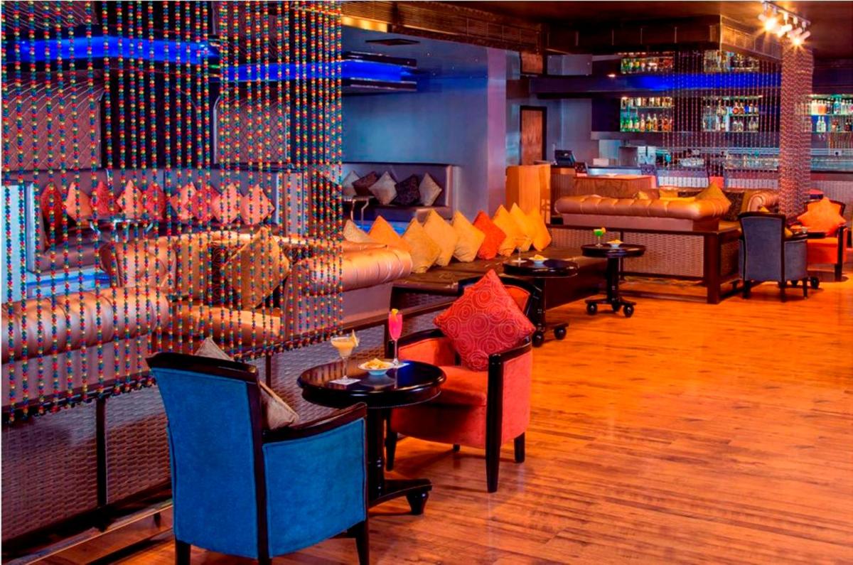 a restaurant with tables and couches and a bar at Radisson Blu Kochi in Cochin