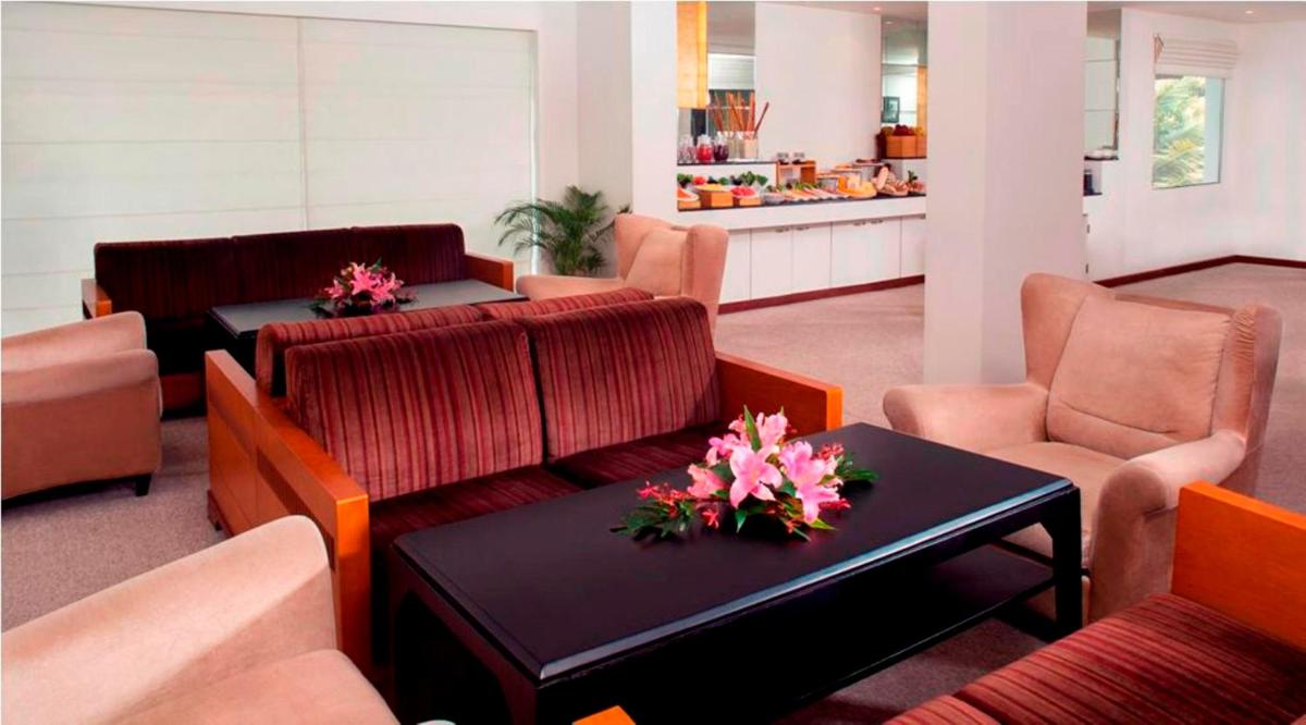 a waiting room with couches and a table and chairs at Radisson Blu Kochi in Cochin