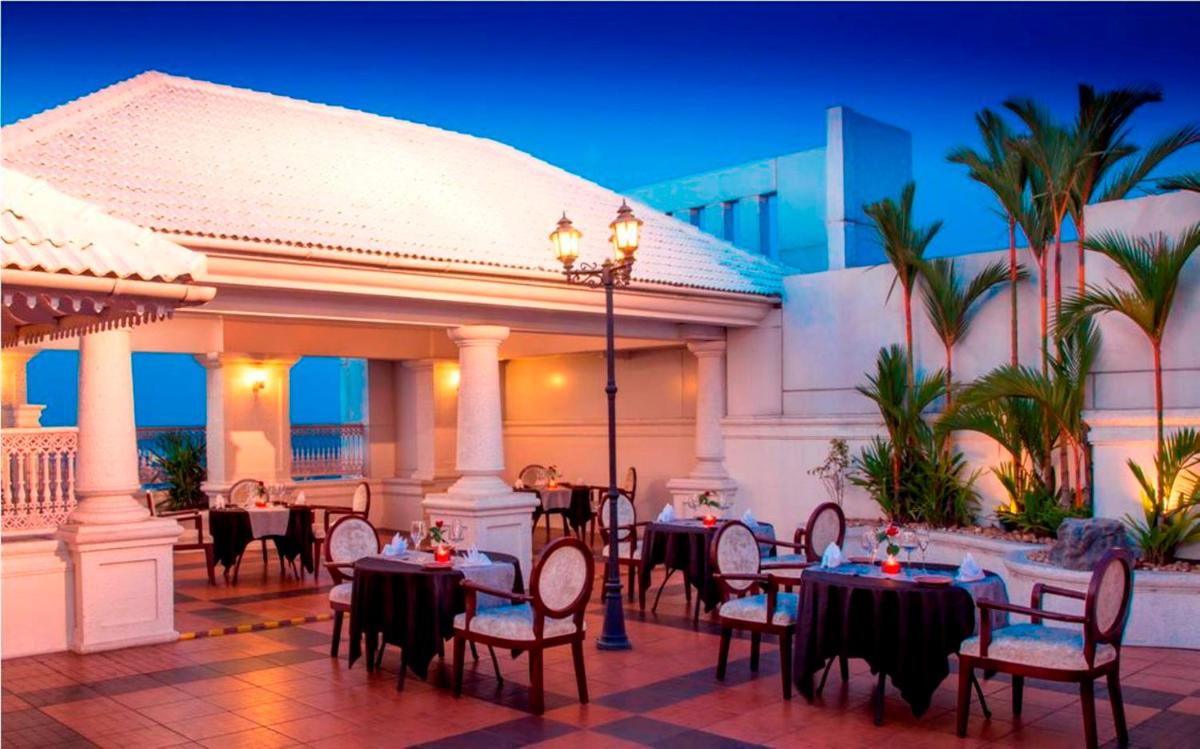 a restaurant with tables and chairs on a patio at Radisson Blu Kochi in Cochin