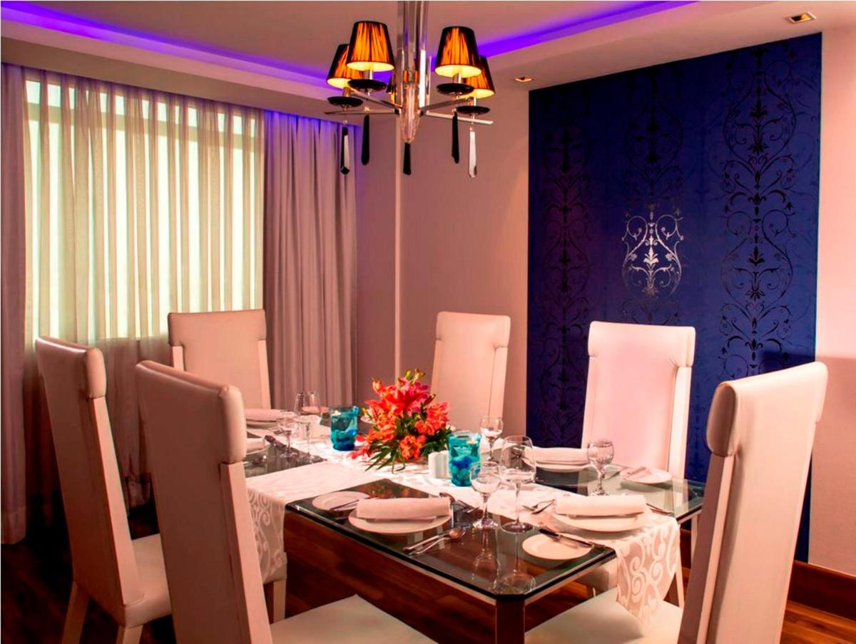 a dining room with a table with white chairs and a dining room at Radisson Blu Kochi in Cochin