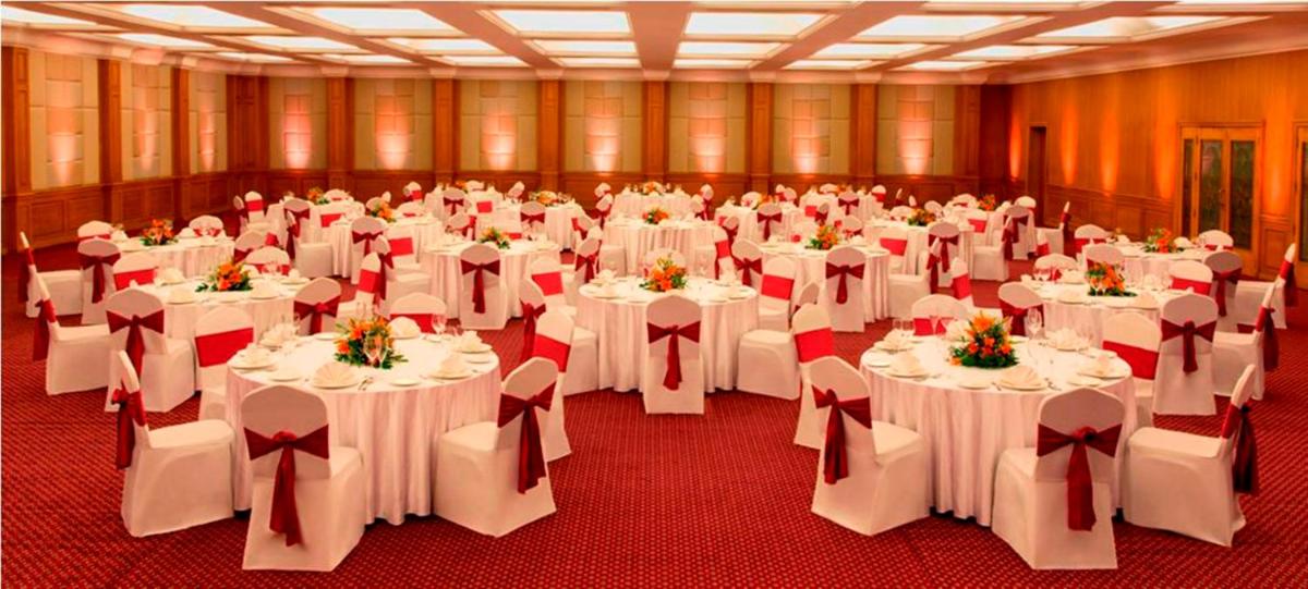 a banquet hall with white tables and white chairs at Radisson Blu Kochi in Cochin