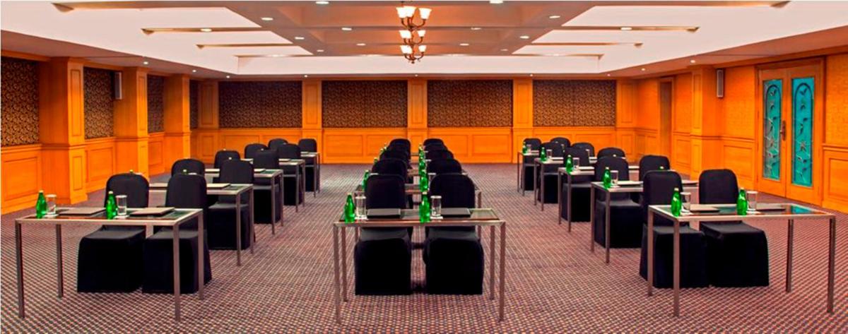 a room filled with tables and chairs with bottles on them at Radisson Blu Kochi in Cochin