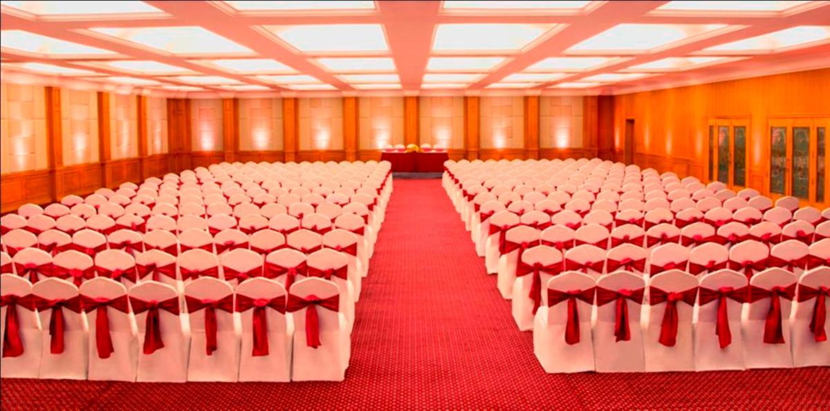 a large room filled with white chairs and a room with red carpet at Radisson Blu Kochi in Cochin
