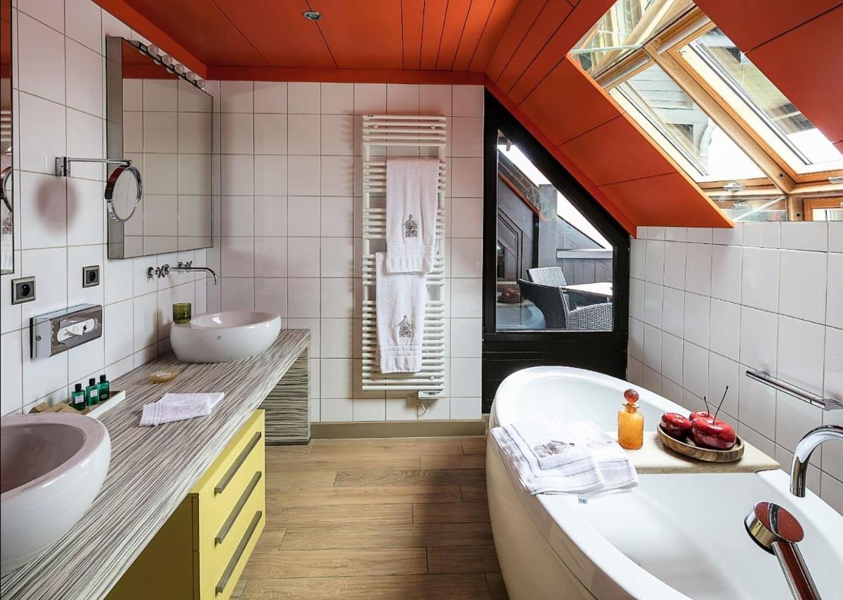une salle de bain avec deux lavabos et une baignoire dans l'établissement Hotel des Berges, Restaurant Gastronomique & Spa, à Illhaeusern
