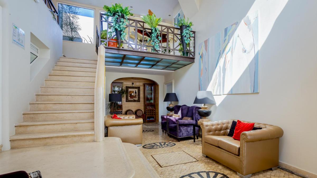 uma sala de estar com escadas e uma escada em Hotel do Cerro em Albufeira