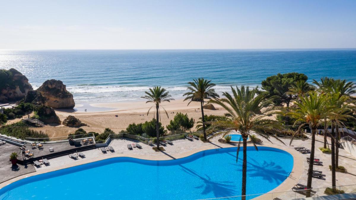 uma vista da praia da varanda de um resort em Pestana Alvor Praia Premium Beach & Golf Resort em Alvor uma vista da praia da varanda de um resort em Pestana Alvor Praia Premium Beach & Golf Resort em Alvor