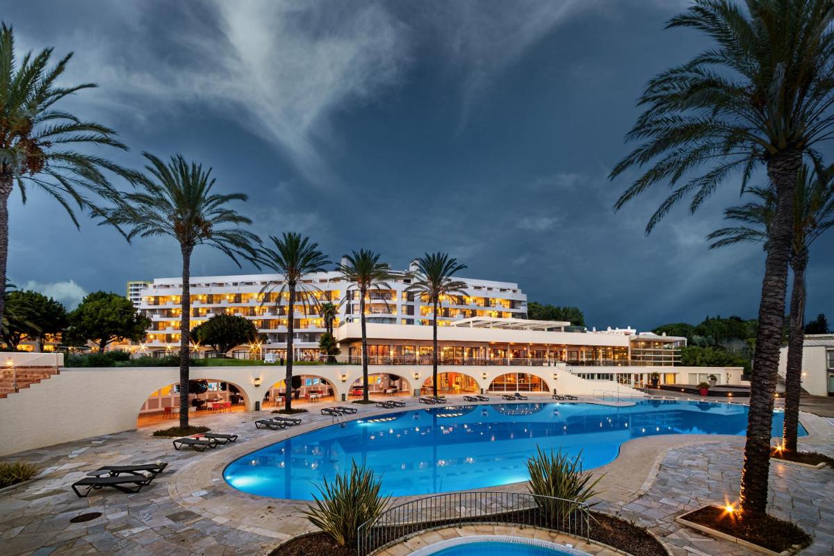 uma vista do resort da piscina em Pestana Alvor Praia Premium Beach & Golf Resort em Alvor uma vista do resort da piscina em Pestana Alvor Praia Premium Beach & Golf Resort em Alvor
