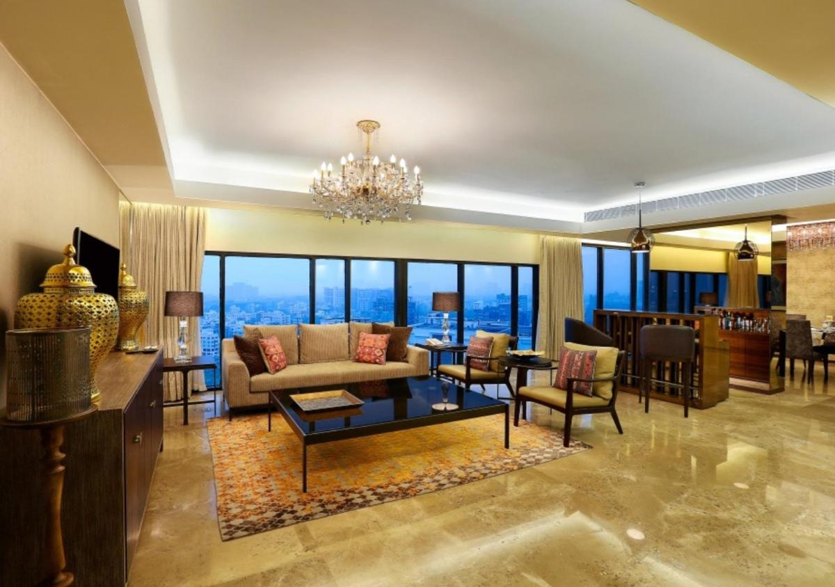 a living room with a chandelier at Novotel Kolkata Hotel and Residences in Kolkata a living room with a chandelier at Novotel Kolkata Hotel and Residences in Kolkata