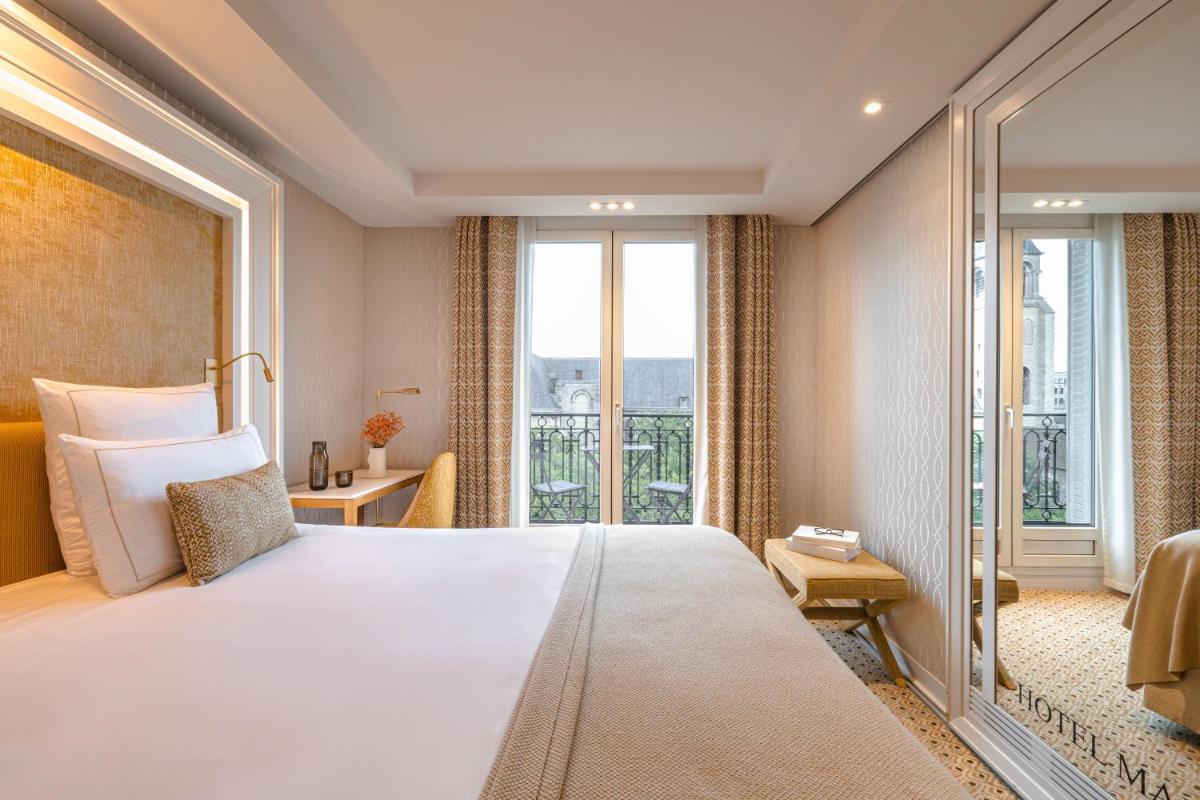 une chambre avec un grand lit et une grande fenêtre dans l'établissement Hôtel Madison, à Paris 47 autres photos