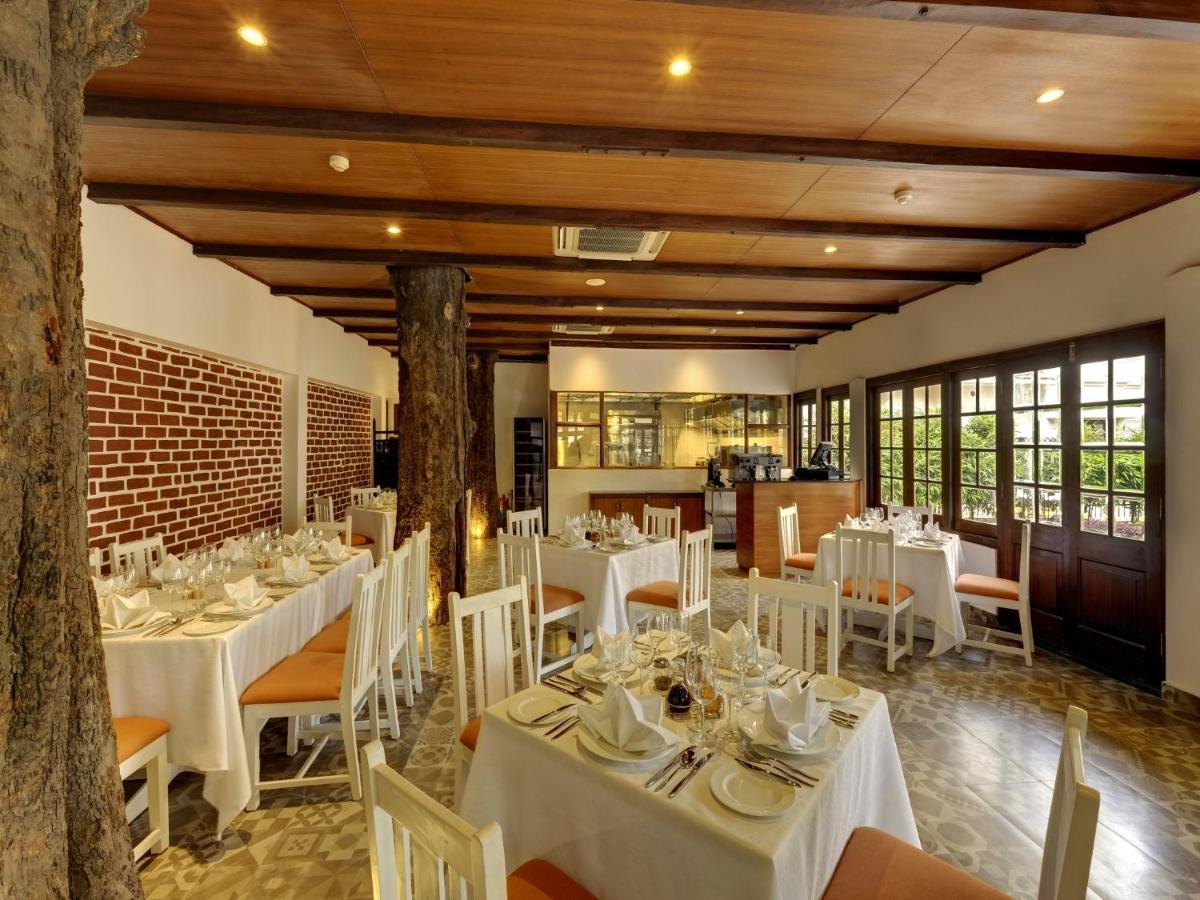 a dining room with white tables and chairs at Saraca Hotel Lucknow in Lucknow