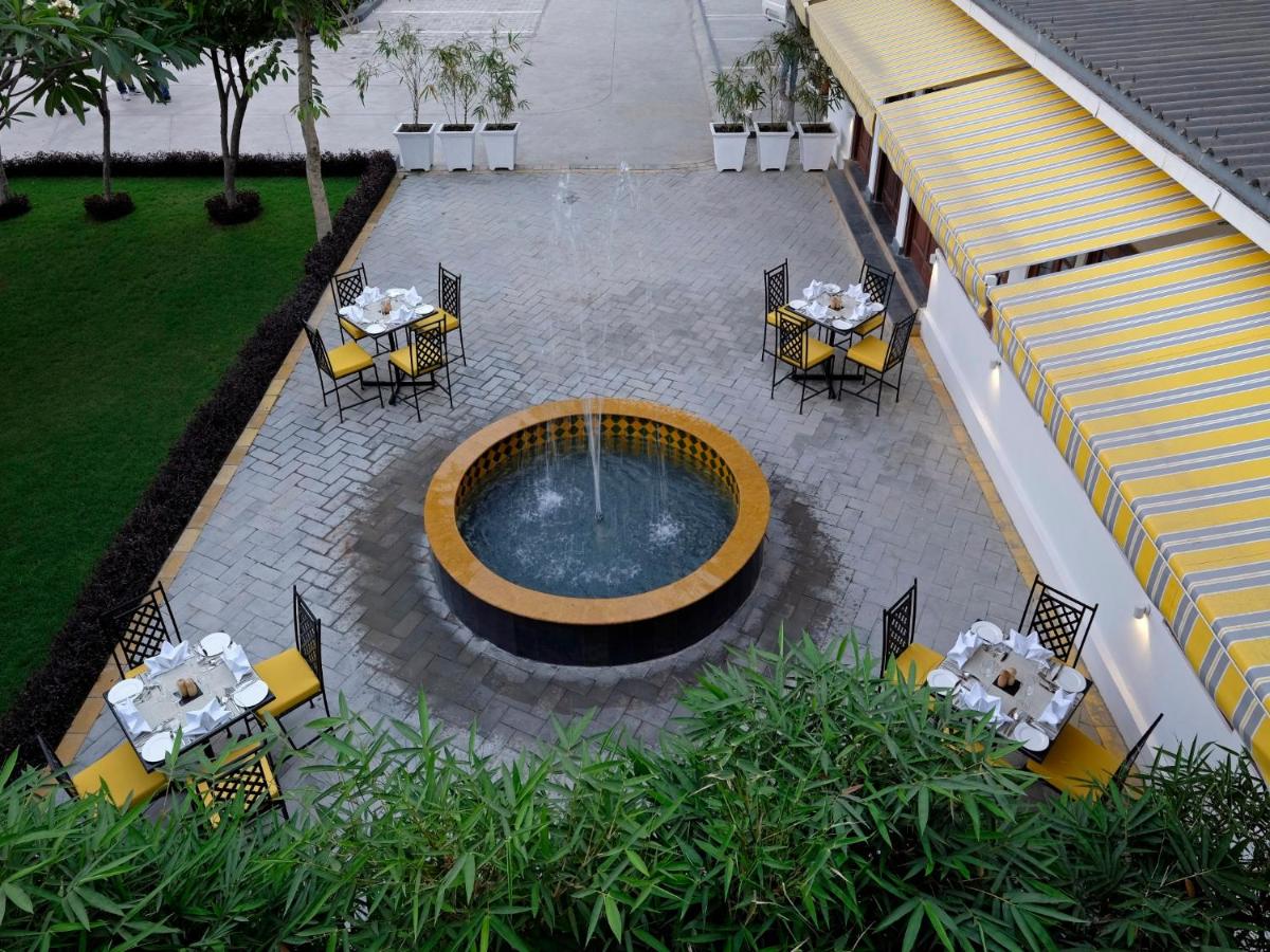 an overhead view of a pool with tables and chairs at Saraca Hotel Lucknow in Lucknow