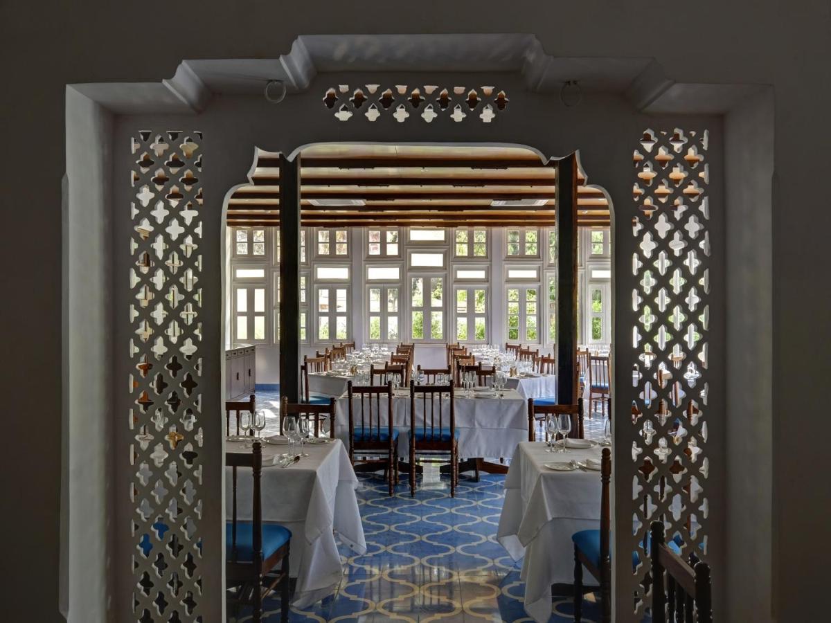 a restaurant with tables and chairs in a room at Saraca Hotel Lucknow in Lucknow