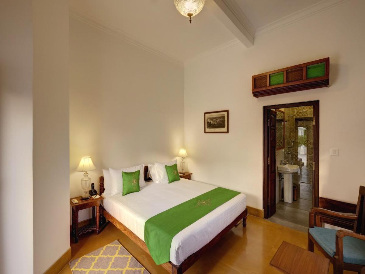 a bedroom with a large bed and a bathroom at Saraca Hotel Lucknow in Lucknow