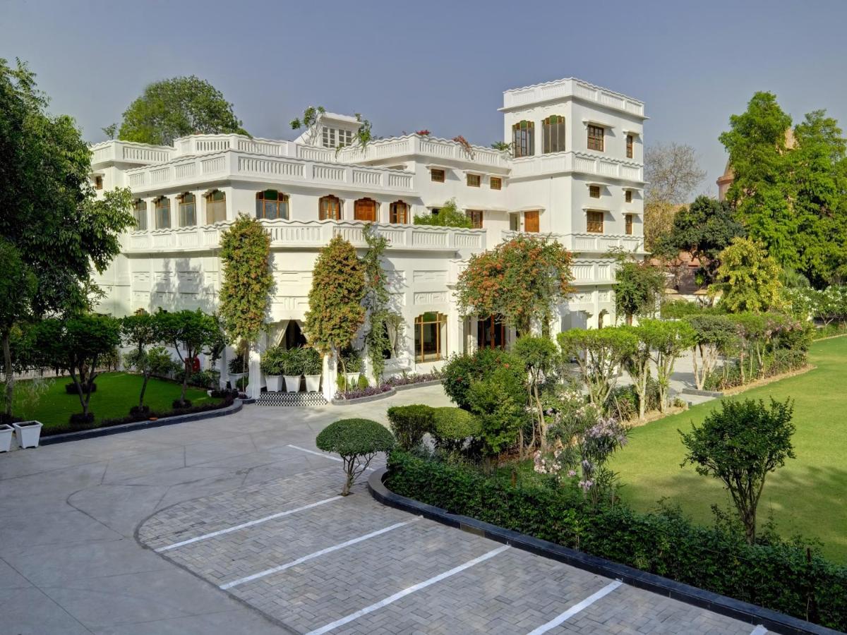 a large white building with a garden in front of it at Saraca Hotel Lucknow in Lucknow