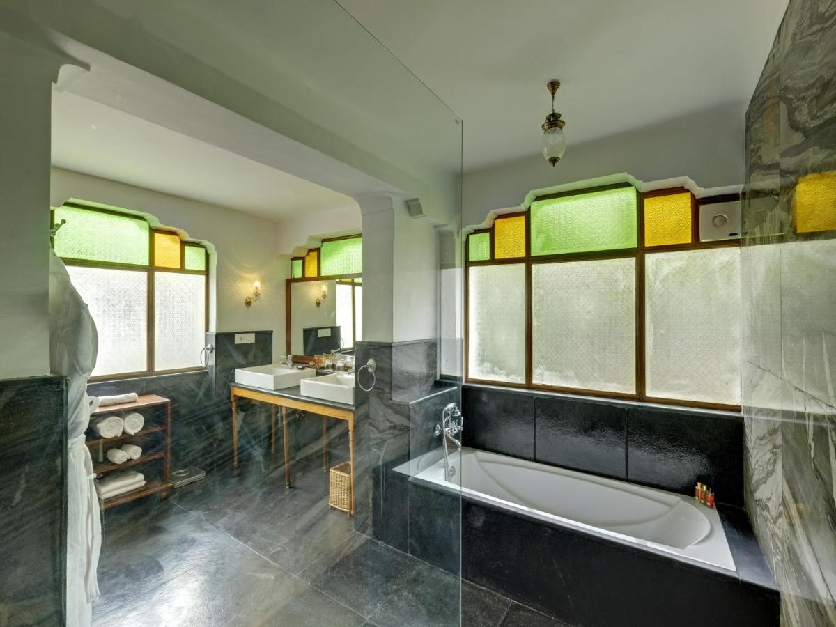 a bathroom with a tub and two sinks and windows at Saraca Hotel Lucknow in Lucknow