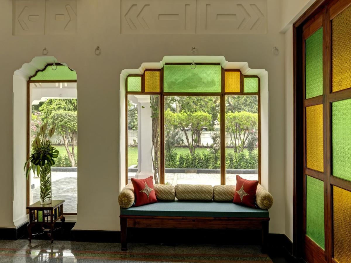 a room with a couch in front of a window at Saraca Hotel Lucknow in Lucknow