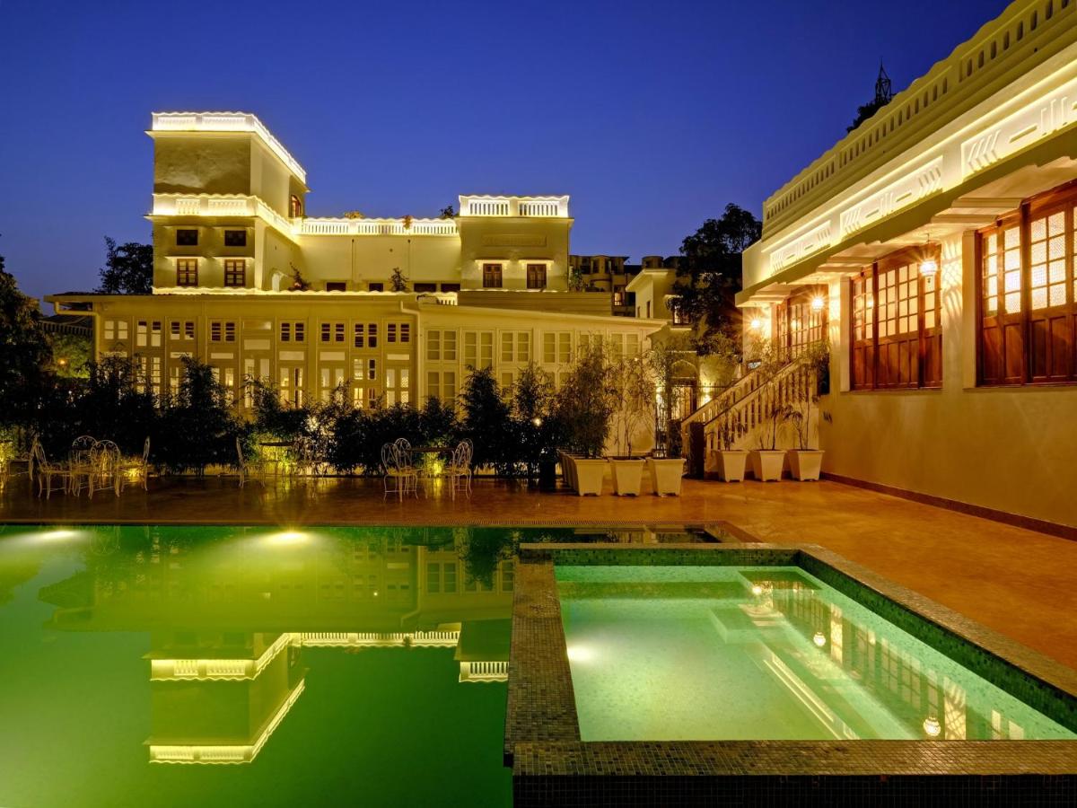 a swimming pool in front of a building at night at Saraca Hotel Lucknow in Lucknow