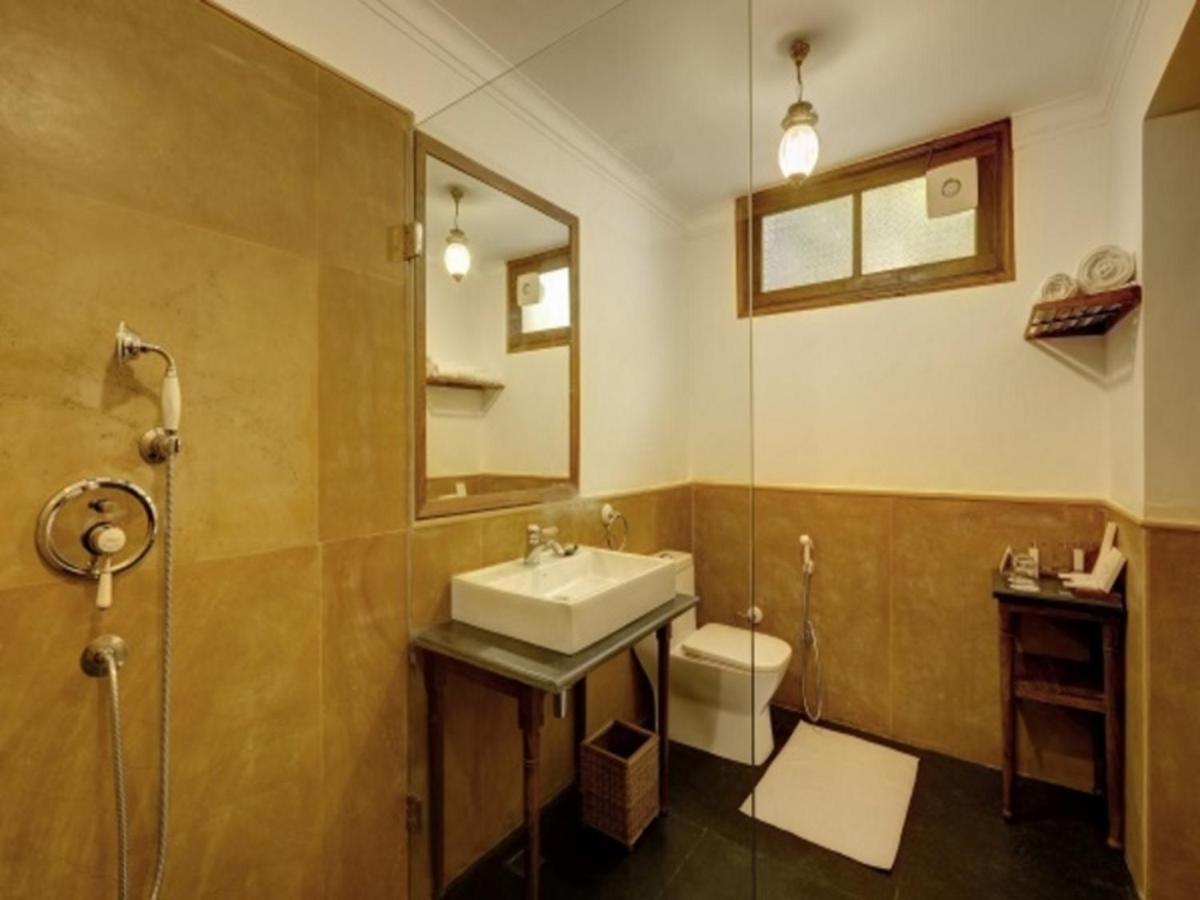 a bathroom with a sink and a toilet and a mirror at Saraca Hotel Lucknow in Lucknow