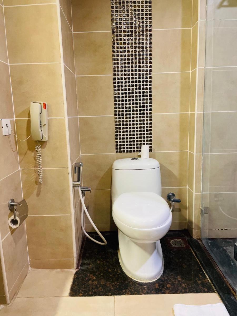 a bathroom with a toilet and a phone at Fortune JP Palace, Mysore - Member ITC Hotels' Group in Mysore