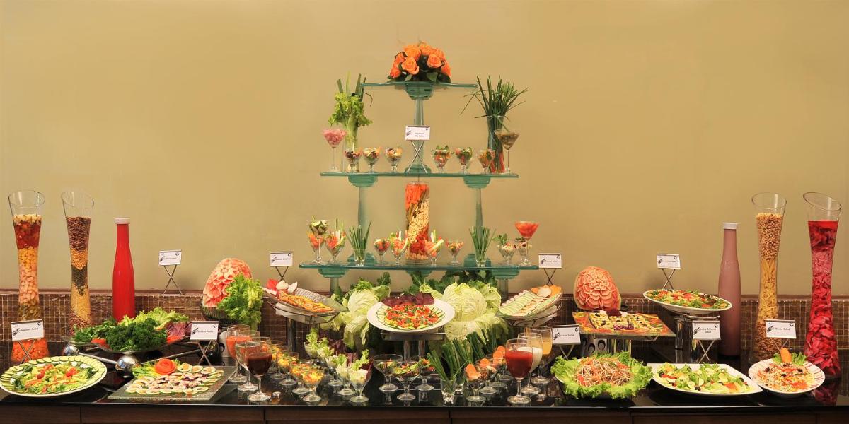 a buffet of food on a table with plates of food at Fortune JP Palace, Mysore - Member ITC Hotels' Group in Mysore