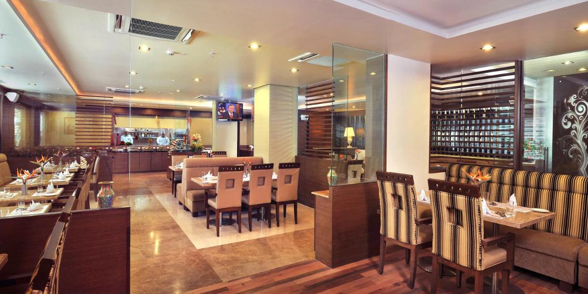 a restaurant with tables and chairs and a bar at Fortune JP Palace, Mysore - Member ITC Hotels' Group in Mysore