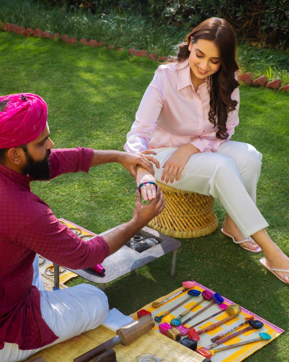 a man and woman sitting on the grass playing with at Hyatt Regency Jaipur Mansarovar in Jaipur a man and woman sitting on the grass playing with at Hyatt Regency Jaipur Mansarovar in Jaipur