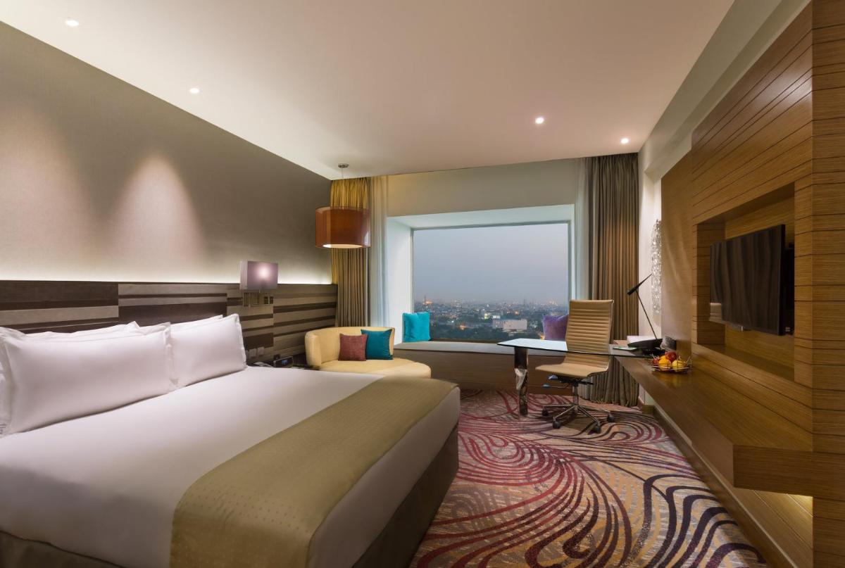 a hotel room with a bed and a desk at Holiday Inn Jaipur City Centre by IHG in Jaipur a hotel room with a bed and a desk at Holiday Inn Jaipur City Centre by IHG in Jaipur