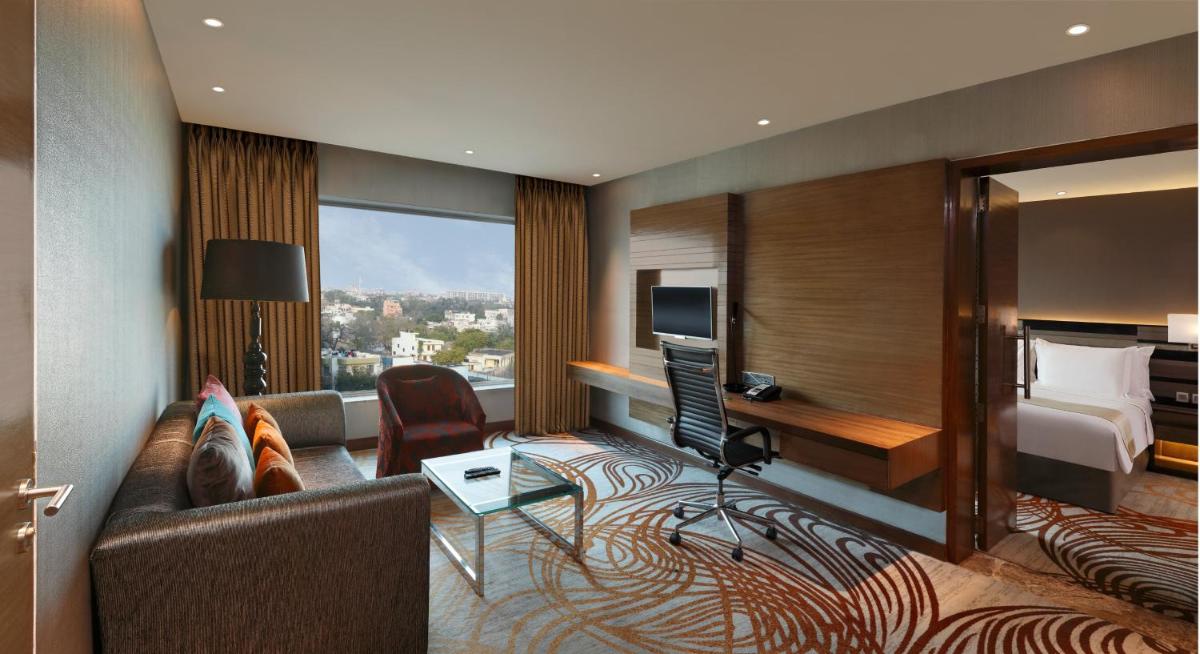 a hotel room with a couch and a bed at Holiday Inn Jaipur City Centre by IHG in Jaipur a hotel room with a couch and a bed at Holiday Inn Jaipur City Centre by IHG in Jaipur
