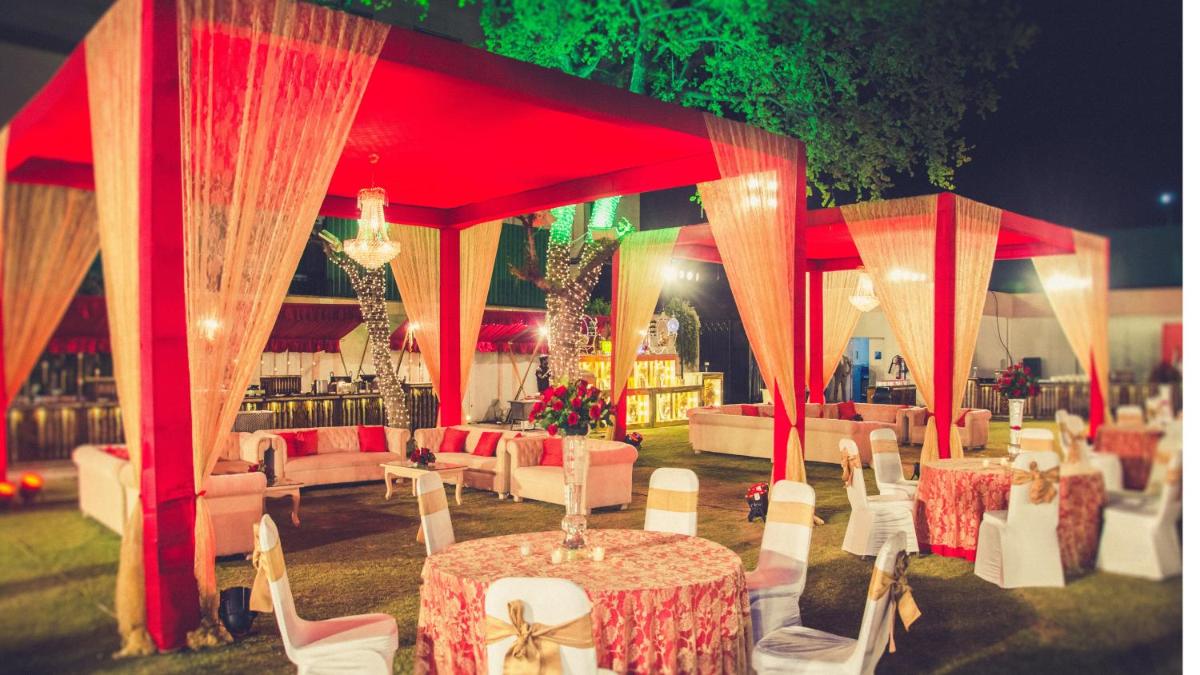 a red tent with tables and chairs in a field at Holiday Inn Jaipur City Centre by IHG in Jaipur a red tent with tables and chairs in a field at Holiday Inn Jaipur City Centre by IHG in Jaipur