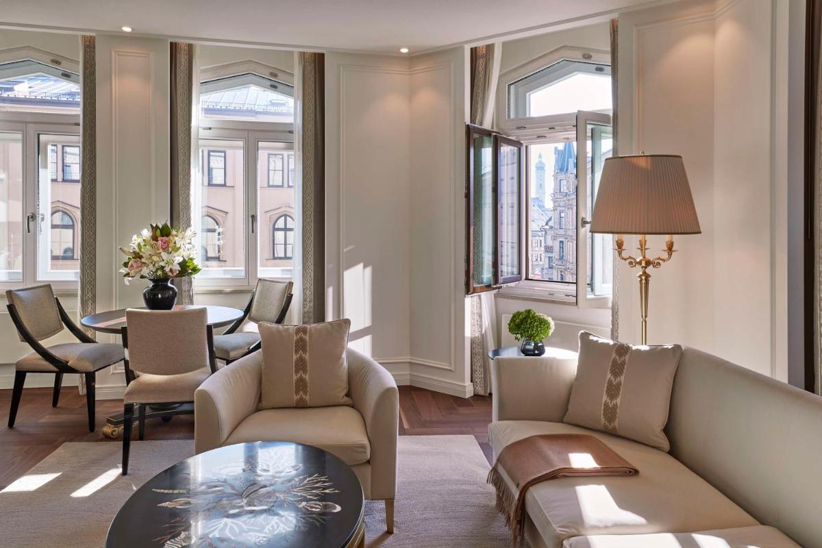 ein Wohnzimmer mit einer Couch und Stühlen und einem Tisch in der Unterkunft Vier Jahreszeiten Kempinski München in München ein Wohnzimmer mit einer Couch und Stühlen und einem Tisch in der Unterkunft Vier Jahreszeiten Kempinski München in München